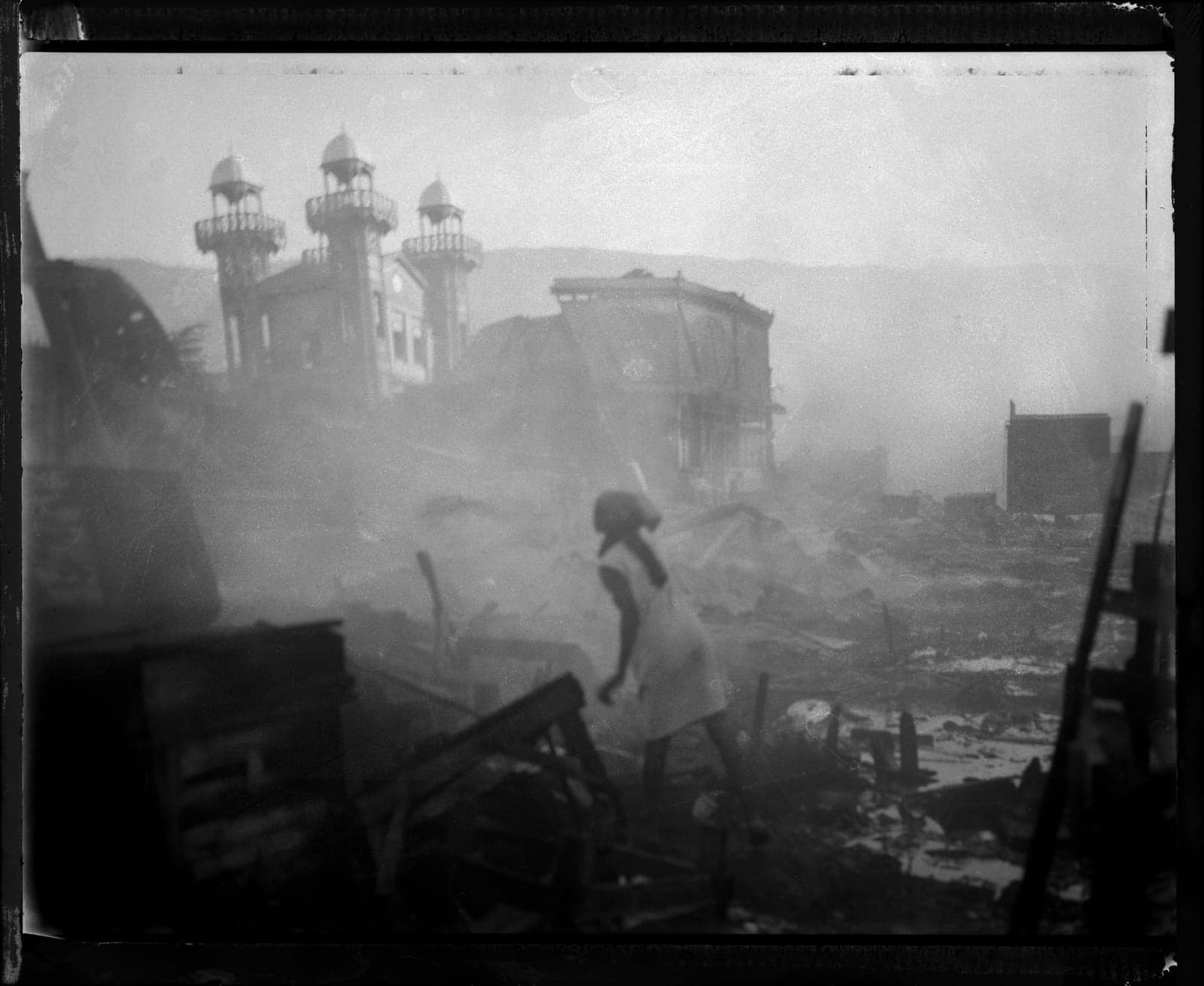 A woman tries to put out a fire that consumed a large portion of the central market in downtown Port au Prince.
Already the poorest country in the Western Hemisphere Haiti experienced a cataclysmic earthquake on January 12, 2010. The disaster rocked the nations capital and shook the small country to its core killing more than 230,000 people and displacing several million. These photographs were made in the weeks after the quake in Port au Prince. The epicenter of this magnitude 7.0 Mw earthquake was near Léogâne, approximately 25 km (16 miles) west of Port-au-Prince, at a depth of 13 km (8.1 miles). The United States Geological Survey recorded a series of at least 33 aftershocks, 14 of which were between magnitudes 5.0 and 5.9. The International Red Cross estimated that about three million people were affected by the quake. As of February 11, 2010 the Haitian Government raised the death toll from the quake to 230,000 people which is by far the worst disaster in Haitian history and one of the most severe natural disasters in recent memory. More than 500,000 people are currently living in makeshift camps throughout the capital city of Port au Prince.