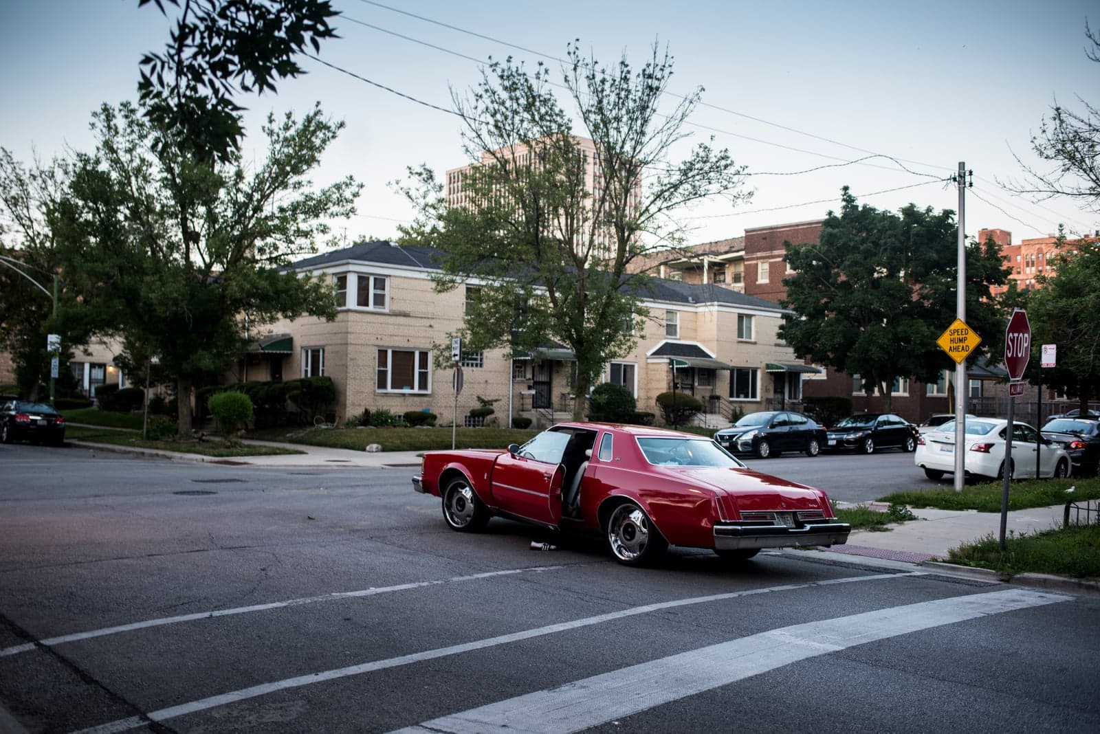 Red classic car with open door at Chicago's South Shore intersection